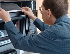 Appliance repair technician replacing a microwave vent filter in Salt Lake City, UT