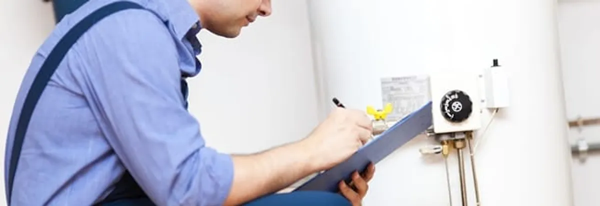 Water heater repair technician inspecting the unit and recording service notes in Salt Lake City, UT